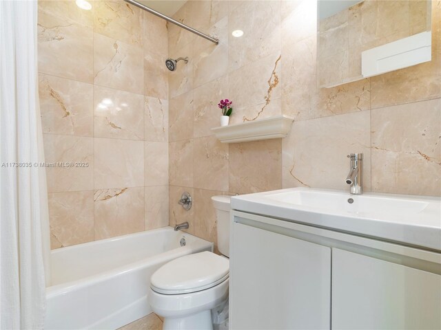 full bathroom featuring shower / bath combination with curtain, vanity, toilet, and tile walls