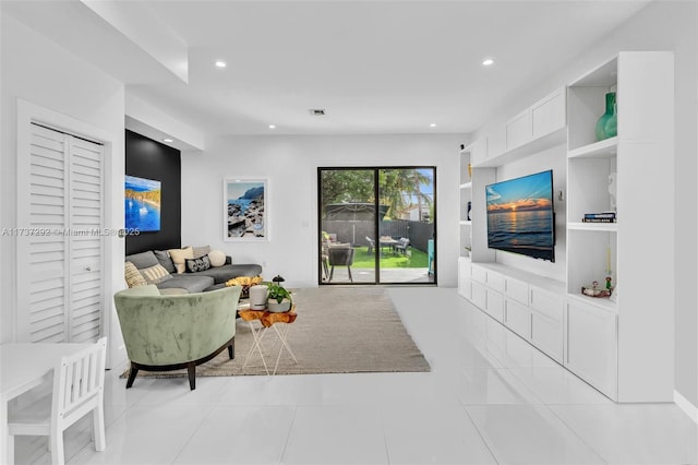 living room featuring built in shelves and light tile patterned flooring