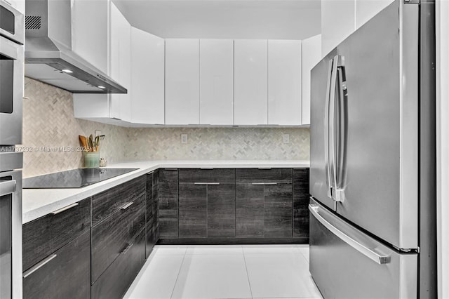 kitchen featuring white cabinetry, stainless steel appliances, decorative backsplash, and wall chimney range hood