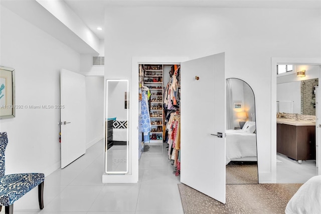 bedroom with ensuite bathroom and a closet