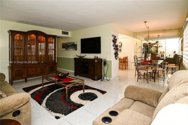 tiled living room featuring a textured ceiling and a notable chandelier