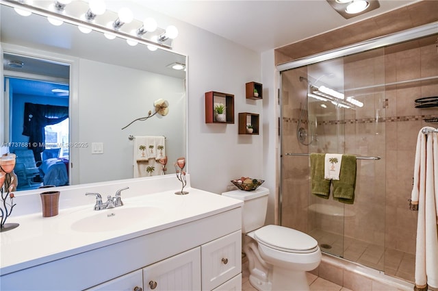 bathroom with vanity, tile patterned flooring, a shower with shower door, and toilet