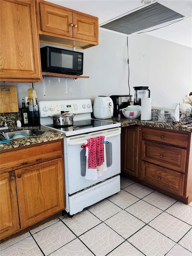 kitchen featuring light tile patterned flooring, white electric range, sink, dark stone countertops, and range hood