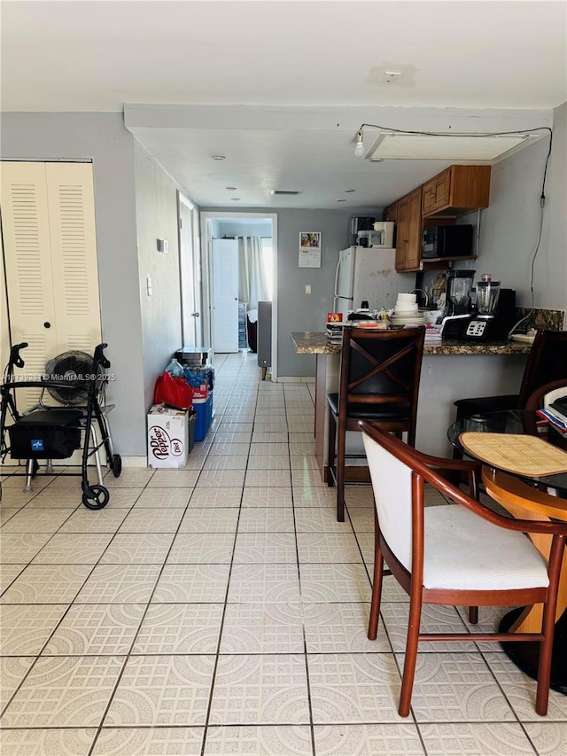 kitchen with white fridge and light tile patterned floors