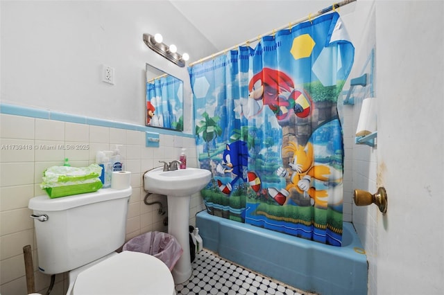 full bathroom with tile walls, sink, toilet, and shower / bath combo with shower curtain