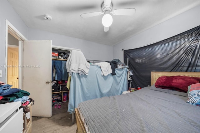 bedroom with light hardwood / wood-style floors, a closet, and ceiling fan