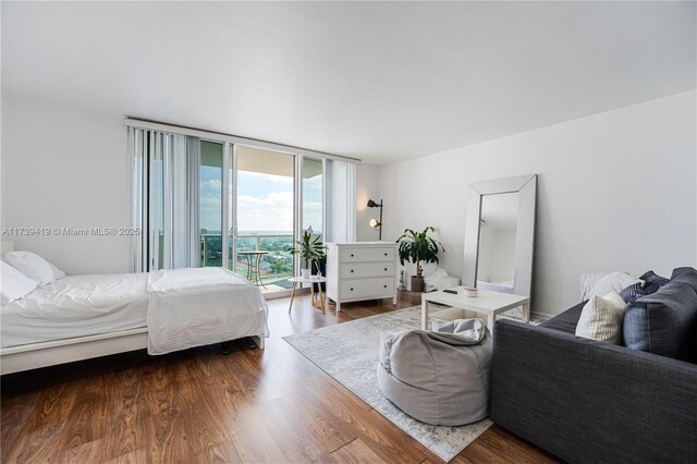 bedroom featuring access to outside, dark hardwood / wood-style floors, and expansive windows