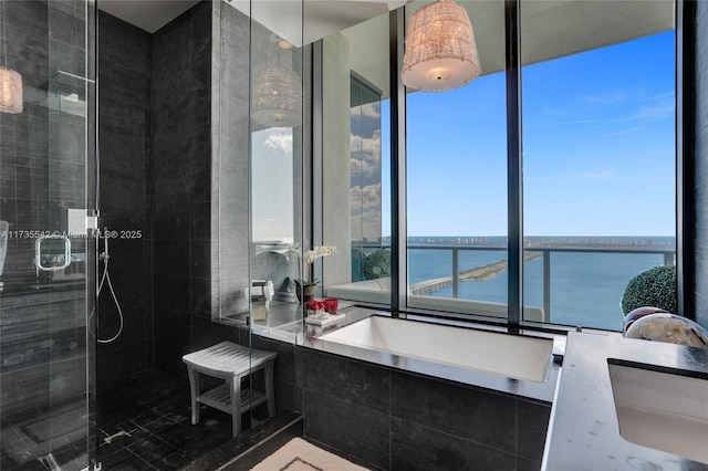 bathroom with vanity, shower with separate bathtub, and a water view