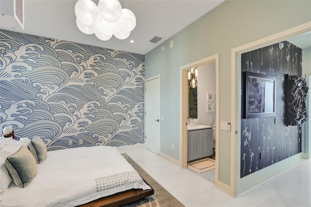 bedroom featuring connected bathroom, light tile patterned floors, and a notable chandelier