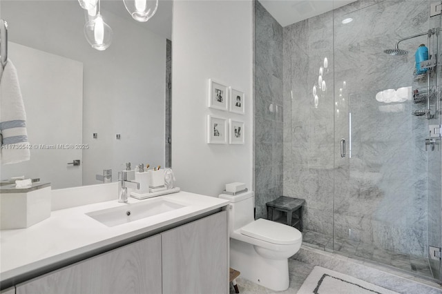 bathroom featuring vanity, a shower with shower door, and toilet