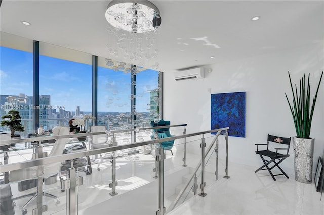 interior space featuring an inviting chandelier, a wall of windows, and a wall mounted air conditioner