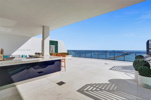 view of patio with a water view and a bar