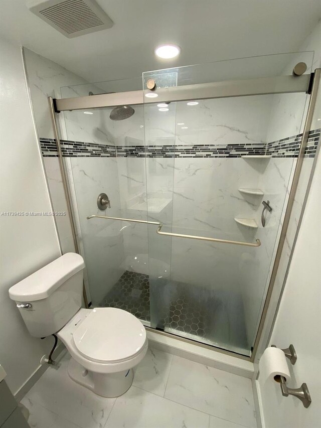 bathroom featuring walk in shower and toilet