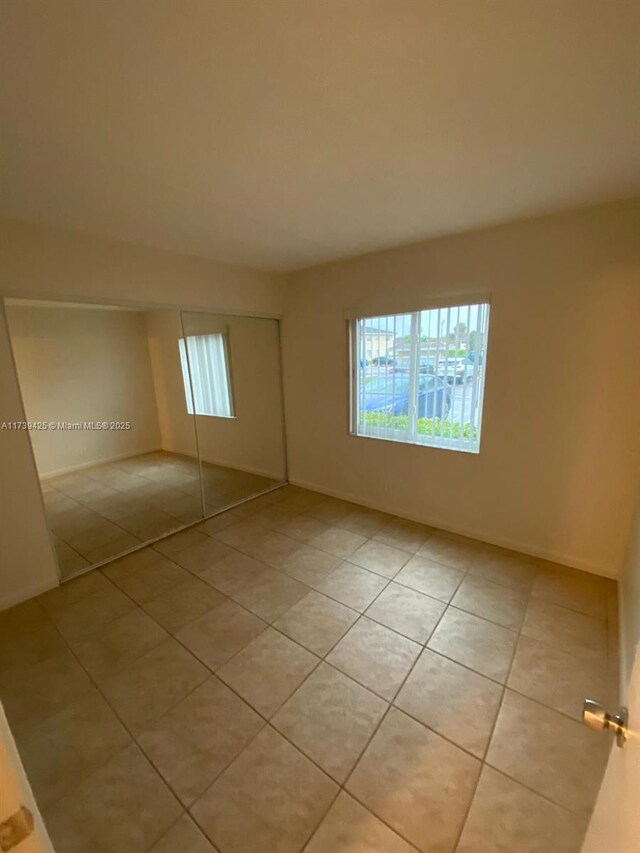 interior space featuring light tile patterned flooring and a closet