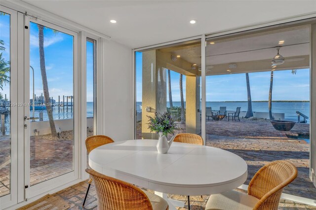 dining space featuring expansive windows and a water view