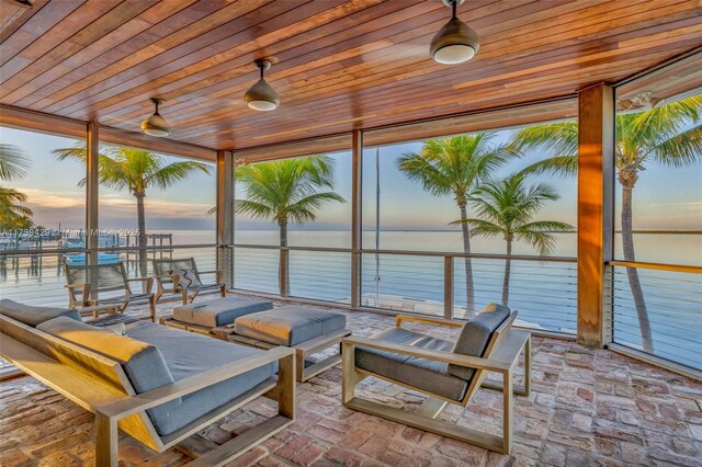 sunroom / solarium featuring wooden ceiling and a water view