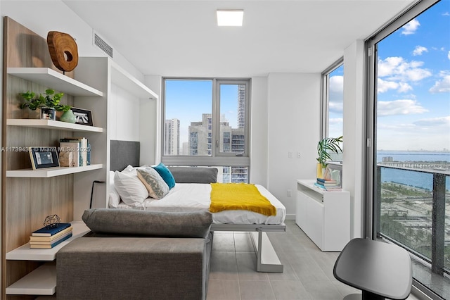 living area with a water view, a wall of windows, and light tile patterned flooring