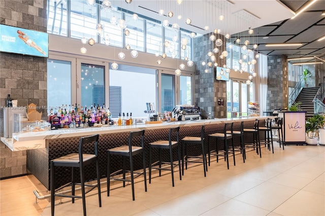 bar with decorative light fixtures and a towering ceiling