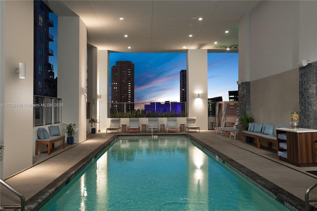 pool at dusk featuring a patio