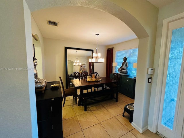 dining room featuring light tile patterned floors and a chandelier