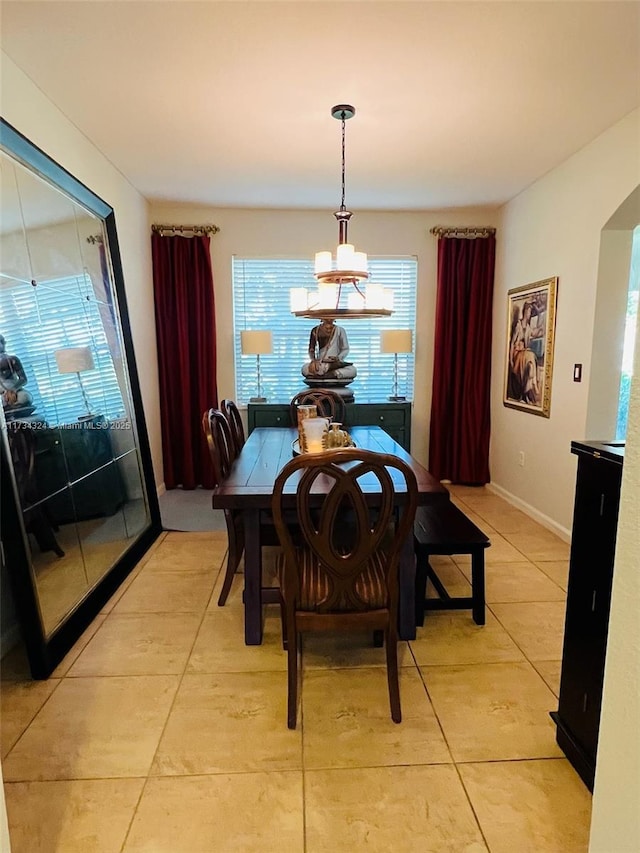 tiled dining space with an inviting chandelier