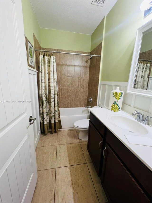 full bathroom featuring vanity, tile patterned flooring, toilet, and shower / bath combo with shower curtain