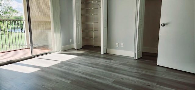 unfurnished bedroom featuring a closet, baseboards, and wood finished floors