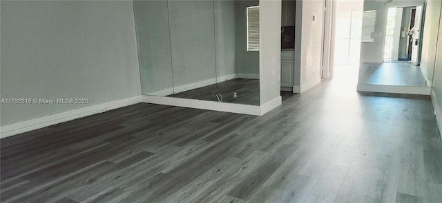 empty room with baseboards and dark wood-style flooring