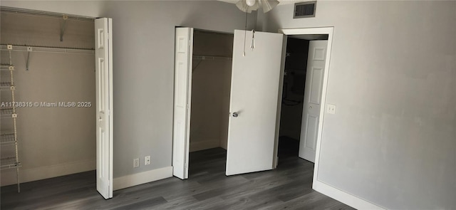 unfurnished bedroom featuring baseboards, visible vents, and dark wood finished floors