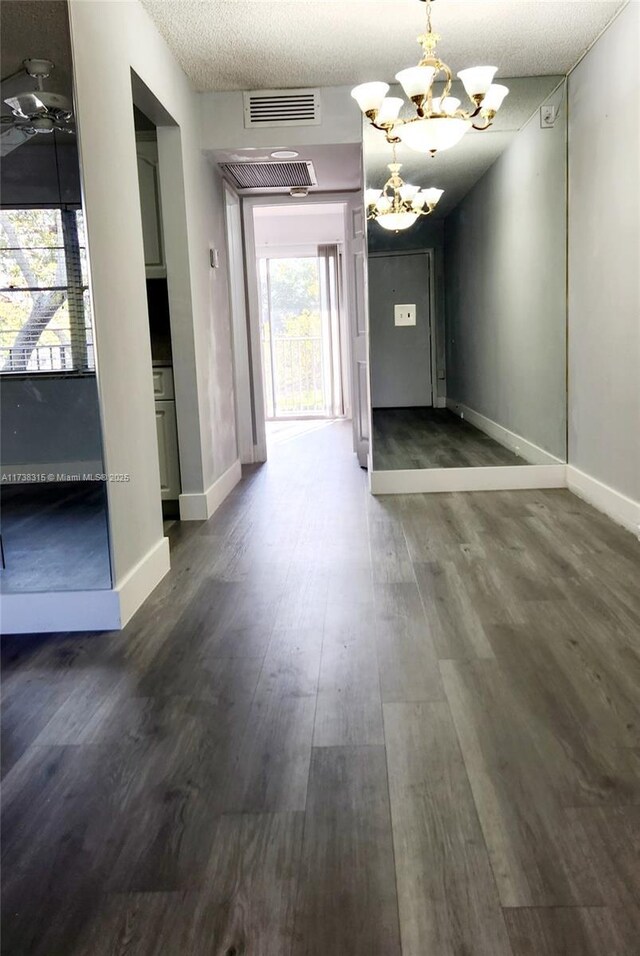 spare room featuring dark wood-type flooring and a textured ceiling