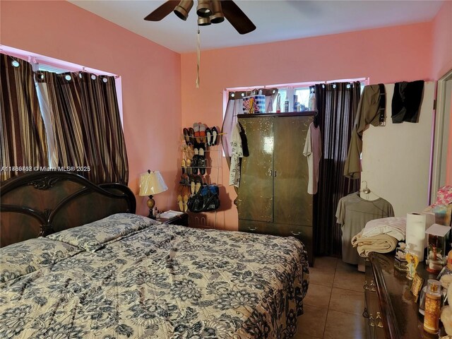 tiled bedroom featuring ceiling fan