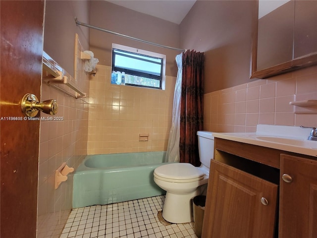 full bathroom with shower / tub combo with curtain, tile walls, tile patterned flooring, vanity, and toilet