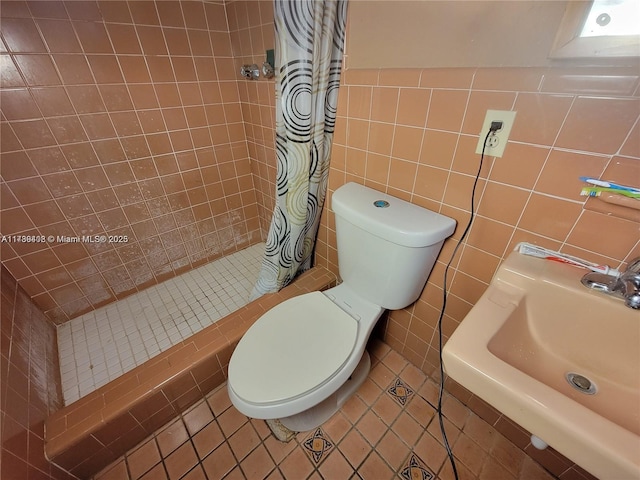 bathroom featuring walk in shower, tile patterned floors, toilet, sink, and tile walls