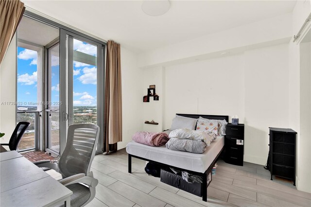 bedroom with access to exterior and a wall of windows