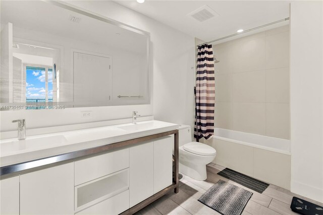 full bathroom featuring shower / tub combo, vanity, and toilet