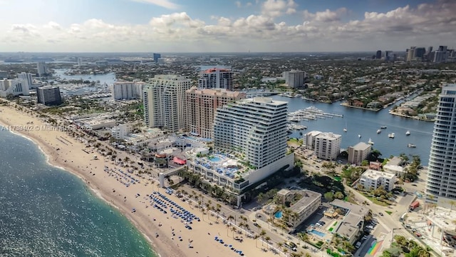 birds eye view of property with a water view and a beach view