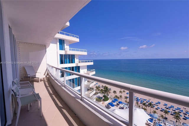 balcony featuring a water view and a beach view