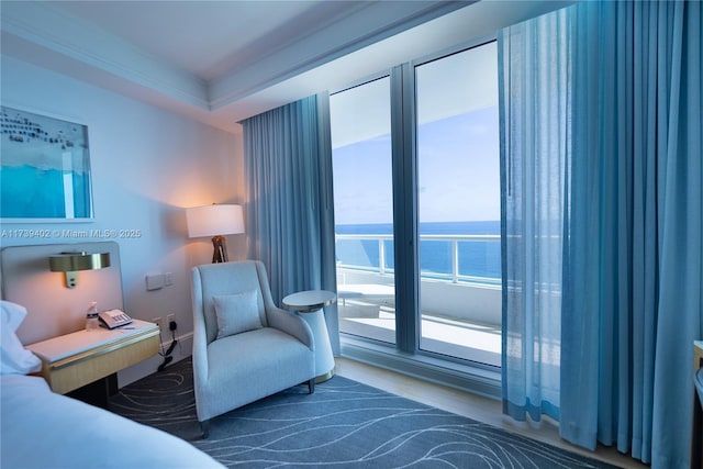 bedroom featuring crown molding and a water view