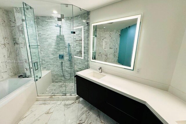 bathroom with vanity and shower with separate bathtub