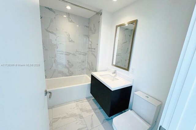 full bathroom featuring vanity, tiled shower / bath combo, and toilet