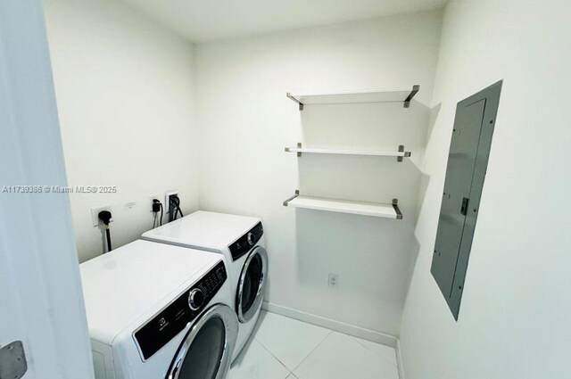 laundry room with light tile patterned floors, washer and clothes dryer, and electric panel