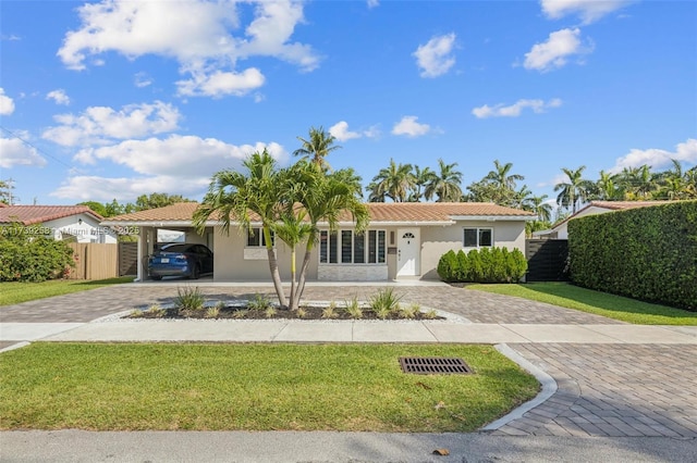 mediterranean / spanish home featuring a front lawn and a carport