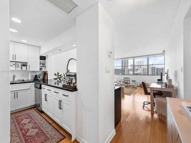 kitchen with white cabinetry, sink, dishwasher, and light hardwood / wood-style floors