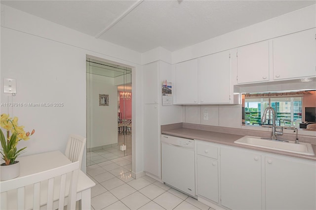 kitchen featuring white cabinetry, sink, light tile patterned floors, white dishwasher, and a textured ceiling