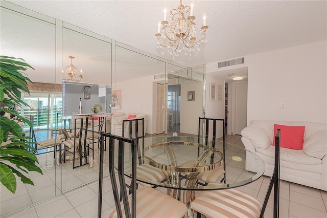 dining room featuring an inviting chandelier, a textured ceiling, and light tile patterned floors