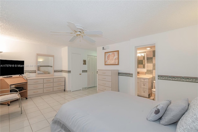 bedroom with connected bathroom, light tile patterned floors, a textured ceiling, and ceiling fan