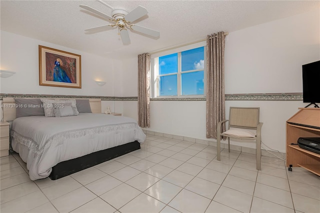 bedroom with a textured ceiling, ceiling fan, and light tile patterned flooring