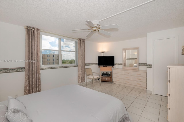 bedroom featuring ceiling fan, a textured ceiling, and light tile patterned flooring