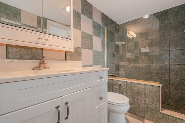 bathroom with tile walls, vanity, and tiled shower