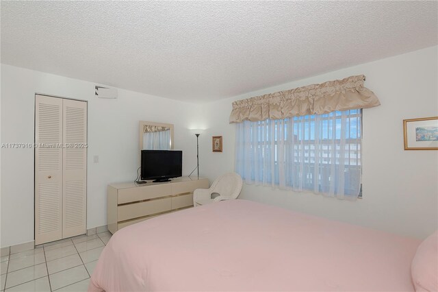 tiled bedroom with a closet and a textured ceiling